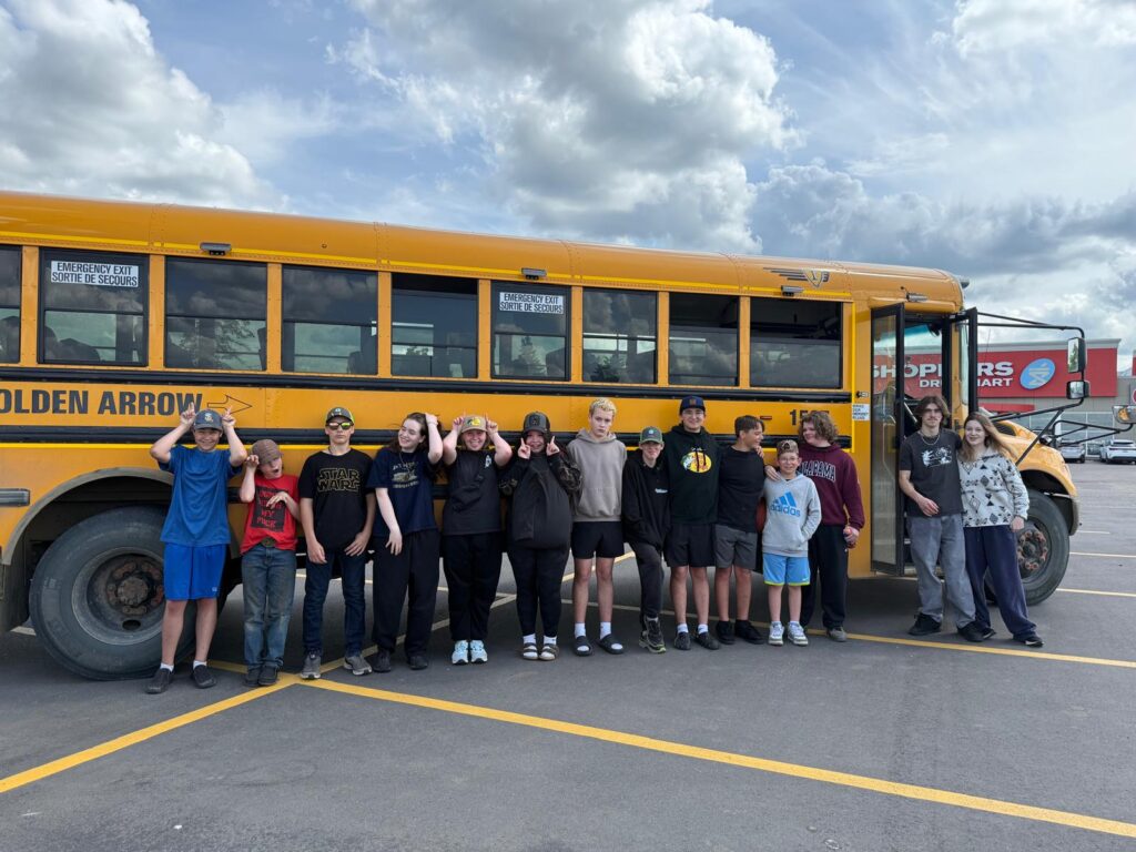 A group of young people standing in front of a school bus