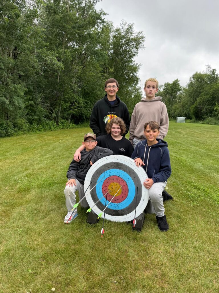 A group of young men around an archery target