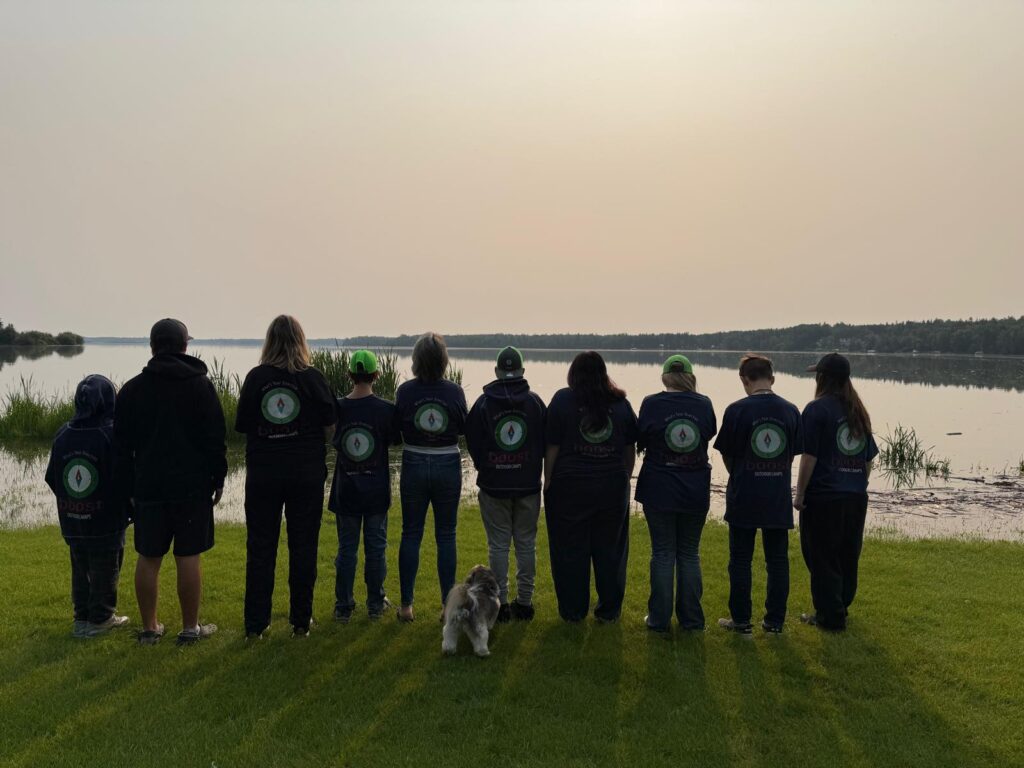 A group of people watching the sunset over a lake